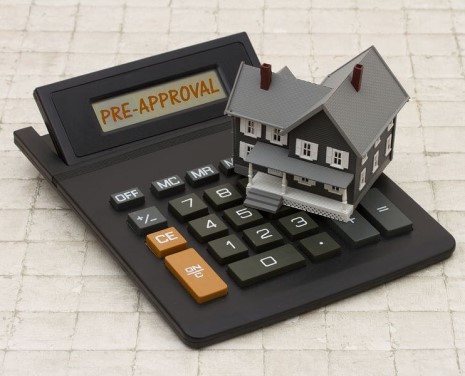 Miniature house over hand calculator
