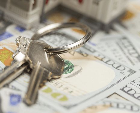 House keys over dollar bills